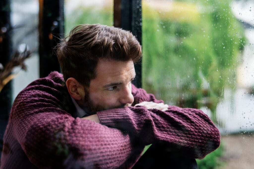 thoughtful-man-looking-out-window-scaled.jpg